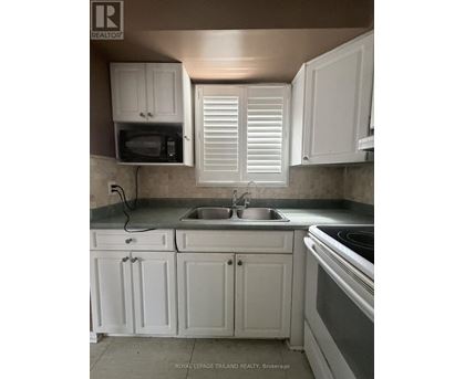 A kitchen with white cabinets and a stove top oven.