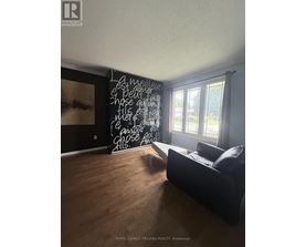 A room with a black couch and a chalkboard with writing on it.