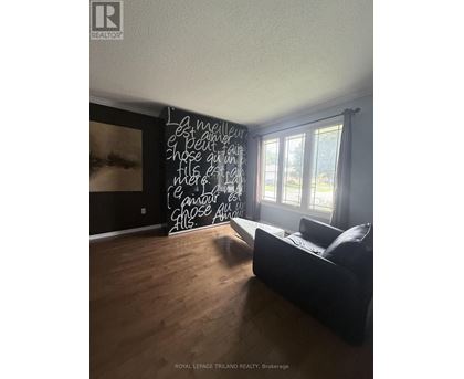 A room with a black couch and a chalkboard with writing on it.