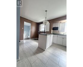 A kitchen with brown walls and white cabinets.