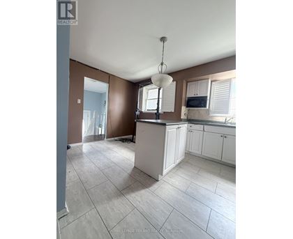 A kitchen with brown walls and white cabinets.
