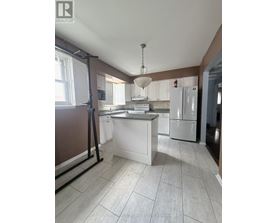 A kitchen with white appliances and a white island.