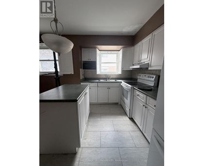 A kitchen with white cabinets and a black counter top.