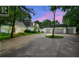 A house with a driveway in front of it at dusk.