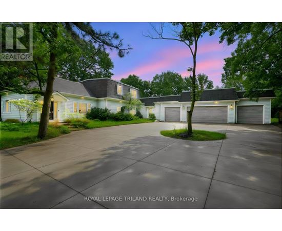 A house with a driveway in front of it at dusk.