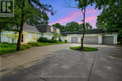 A house with a driveway in front of it at dusk.