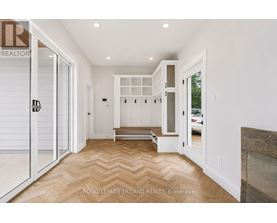 A hallway with a bench and a door leading to a balcony.