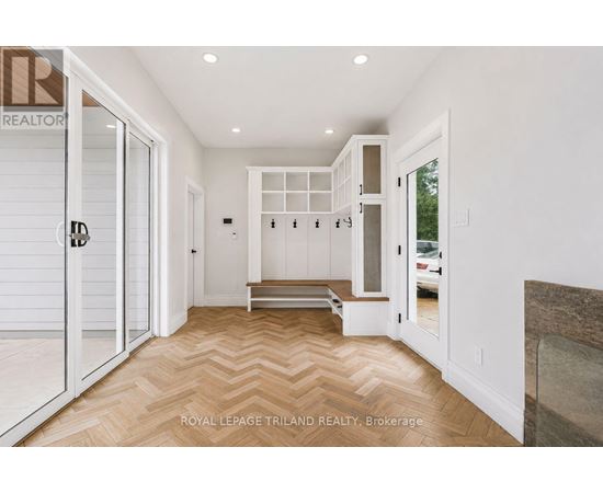 A hallway with a bench and a door leading to a balcony.