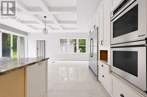 A modern kitchen with white cabinets and a marble countertop.
