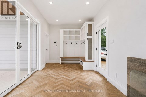 A hallway with a bench and a door leading to a balcony.