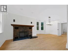 A spacious room with a fireplace and a chandelier.