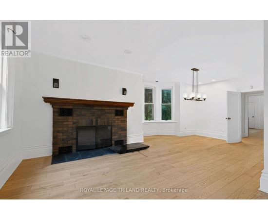 A spacious room with a fireplace and a chandelier.