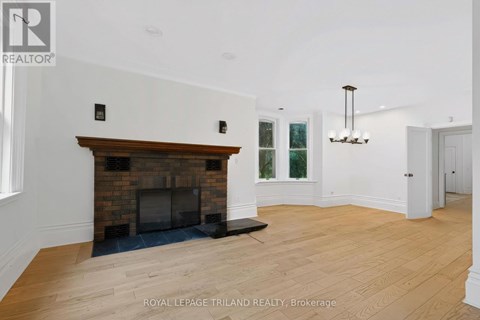 A spacious room with a fireplace and a chandelier.