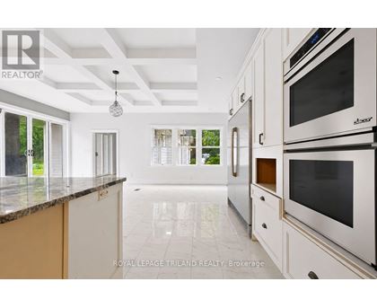 A modern kitchen with white cabinets and a marble countertop.