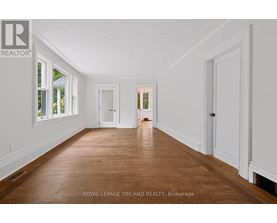 A spacious room with wooden floors and white walls.