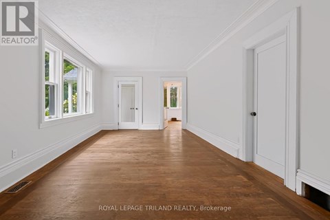 A spacious room with wooden floors and white walls.