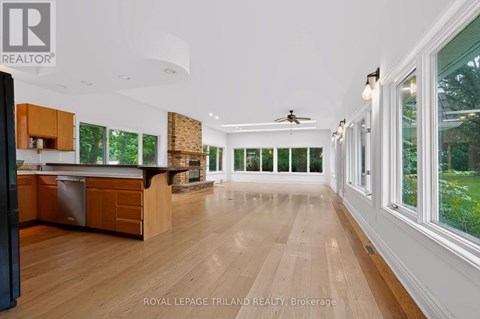 A spacious kitchen with wooden floors and a ceiling fan.
