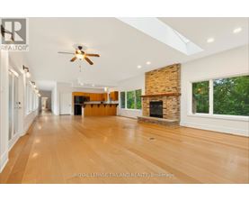A spacious room with wooden floors and a fireplace.