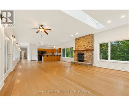 A spacious room with wooden floors and a fireplace.