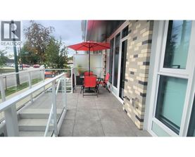A balcony with a table and chairs and an umbrella.