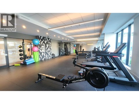 A gym with a variety of equipment including treadmills, exercise bikes, and weights.