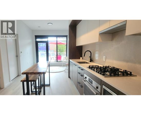 A modern kitchen with a wooden table and stainless steel appliances.