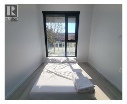 A bedroom with a bed and a window.