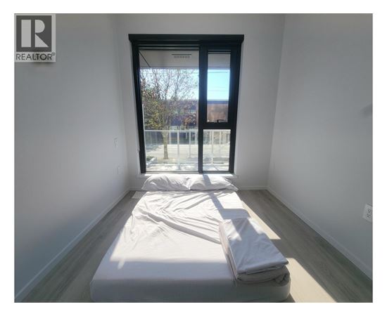 A bedroom with a bed and a window.