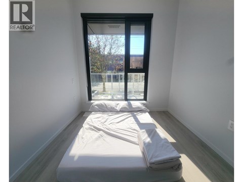 A bedroom with a bed and a window.