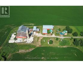 An aerial view of a farm with a red barn and a green field.
