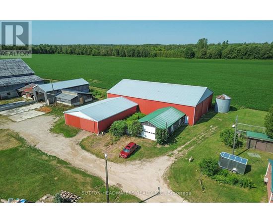 A red barn with a green roof is surrounded by a grassy field.