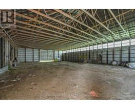 A large, empty warehouse with a high ceiling and metal beams.