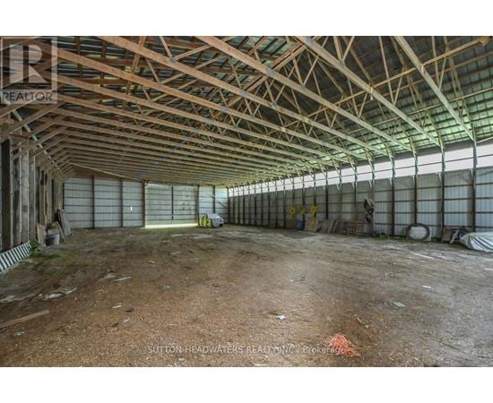 A large, empty warehouse with a high ceiling and metal beams.