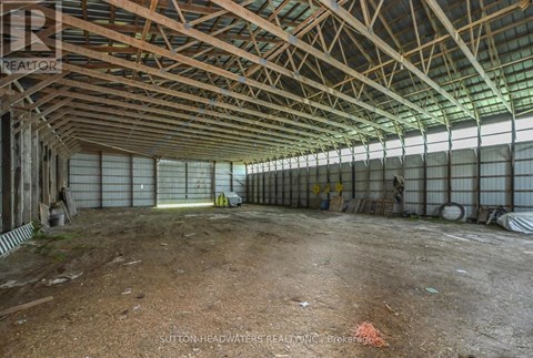 A large, empty warehouse with a high ceiling and metal beams.