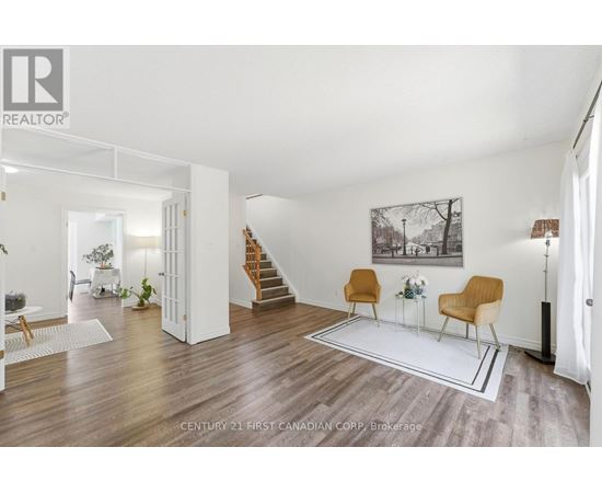 A living room with a white wall and a painting hanging on it.