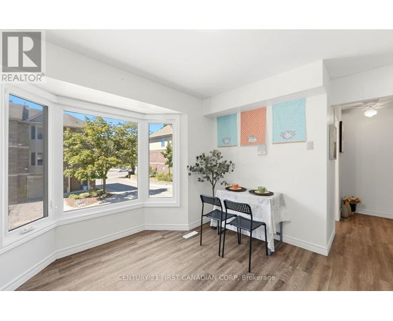 A dining room with a table set for two and a view of the street outside.
