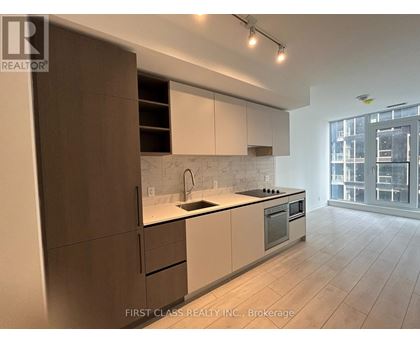 A modern kitchen with white and brown cabinets and a large window.
