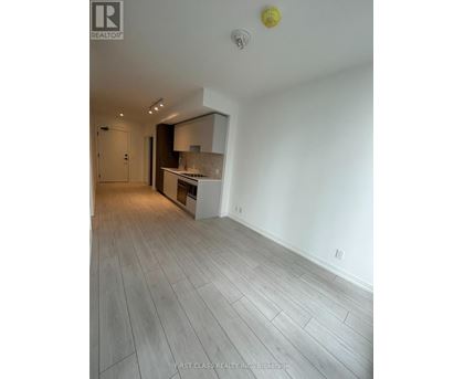 A spacious room with a grey floor and white walls.