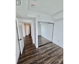 A hallway with wood flooring and white walls.
