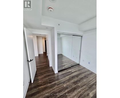 A hallway with wood flooring and white walls.