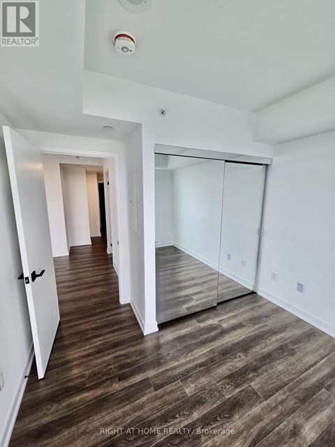 A hallway with wood flooring and white walls.