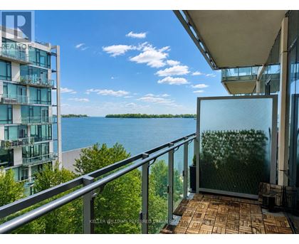 A balcony with a glass door overlooking a body of water.