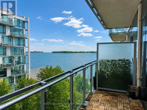 A balcony with a glass door overlooking a body of water.