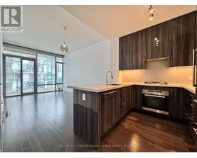 A modern kitchen with dark wood cabinets and a stainless steel oven.