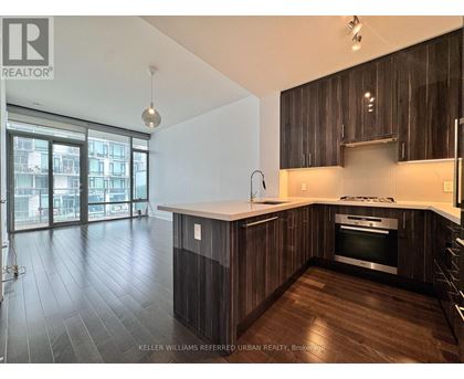A modern kitchen with dark wood cabinets and a stainless steel oven.