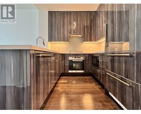 A modern kitchen with wood grain cabinets and a central island.