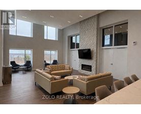 A living room with a stone wall and a fireplace.