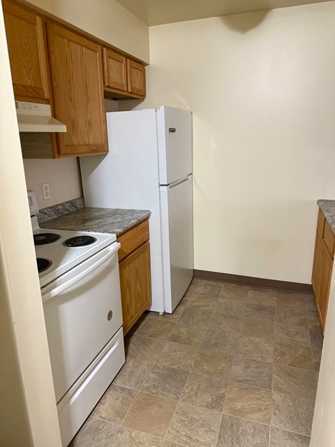 A kitchen with a white fridge and a white stove.