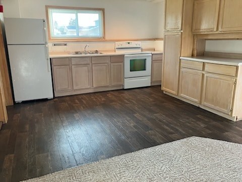 A kitchen with wooden floors and white appliances.