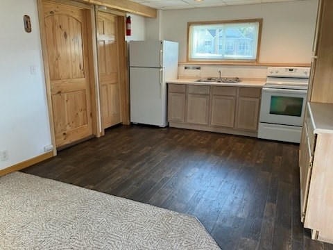 A kitchen with a refrigerator, oven, and microwave.